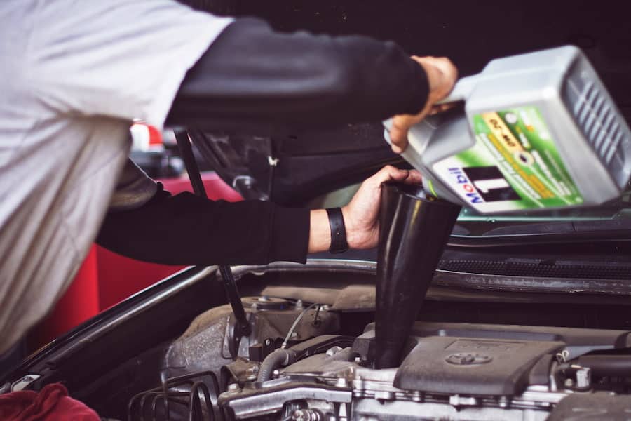 A man pouring motor oil