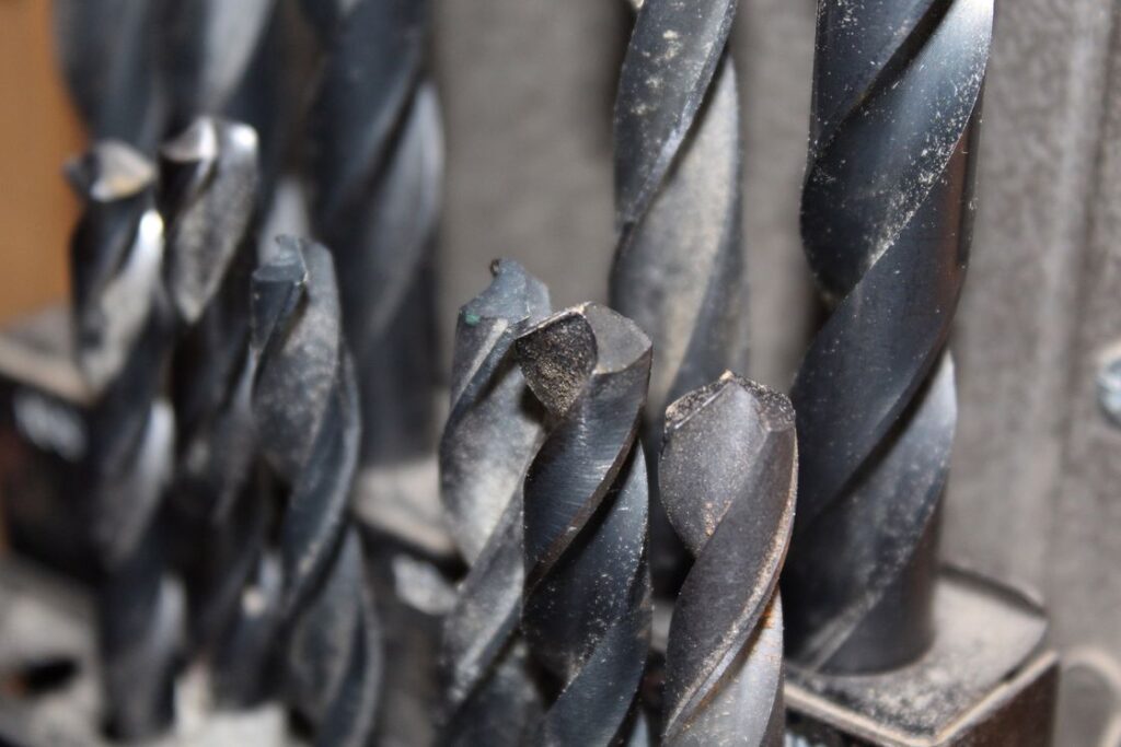 Drill bits with leftover sawdust aligned upright in its organizer