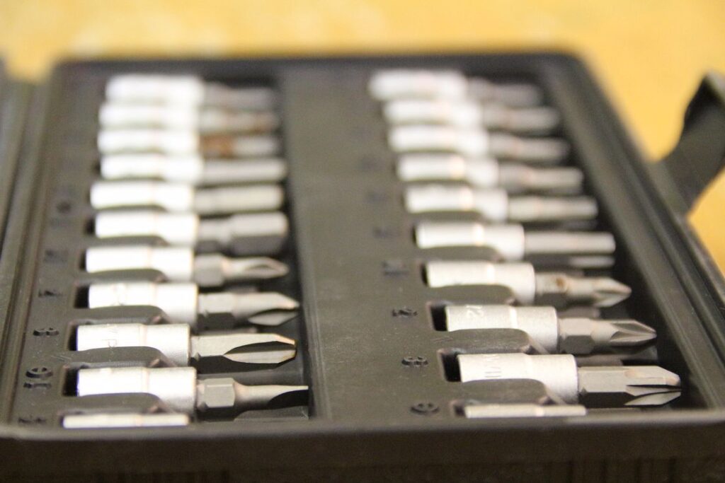 Different sizes and kinds of drill bits in a black storage case