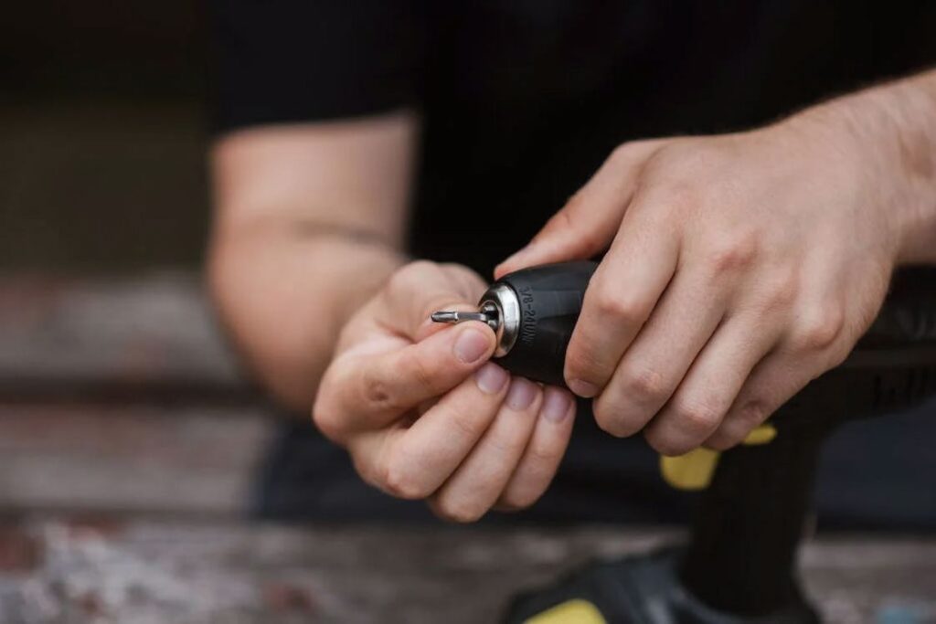 Man replacing a drill bit in a drill