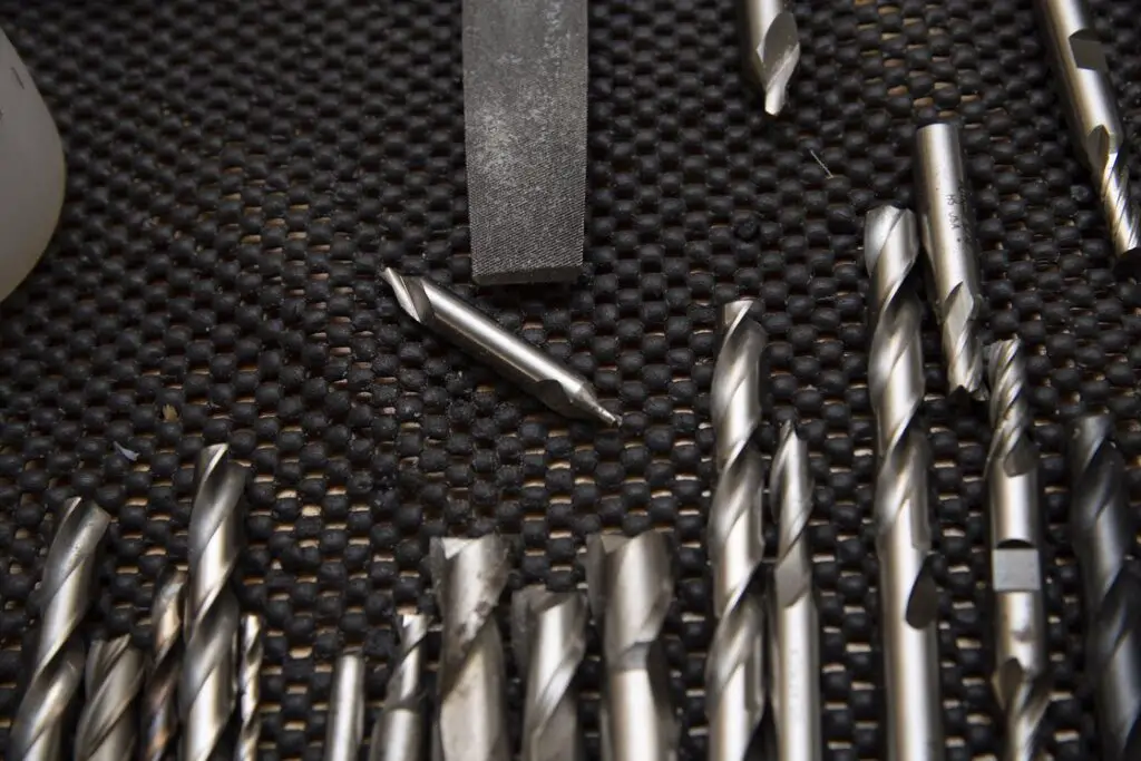Different kinds of drill bits laid out on a table