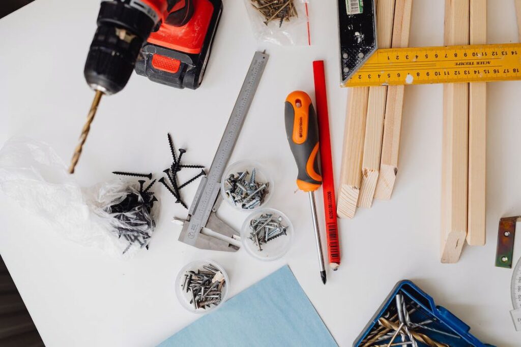 Drill, screws and other woodworking tools on a table