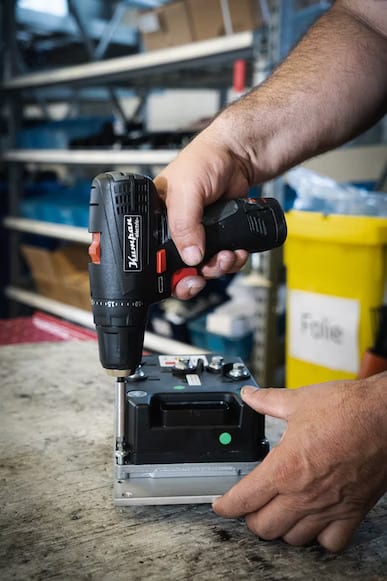 Man attaching a screw with a drill in an aluminum heatsink