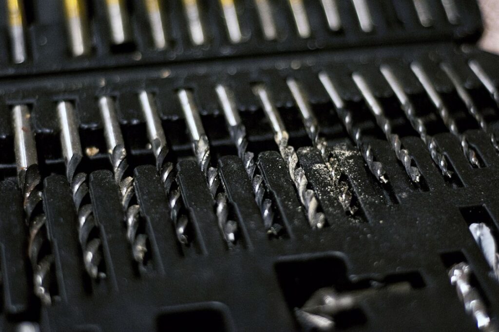 Drill bits covered in saw dust and stored on its container