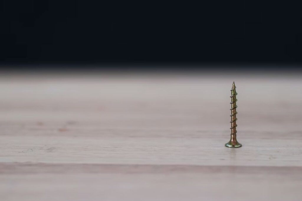 Rusty screw standing upright on a table