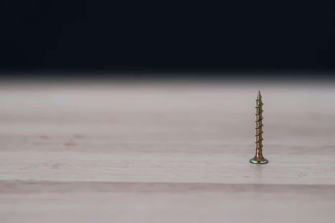 Rusty screw standing upright on a table