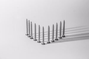 Silver screws placed upright and forming a V on a white table