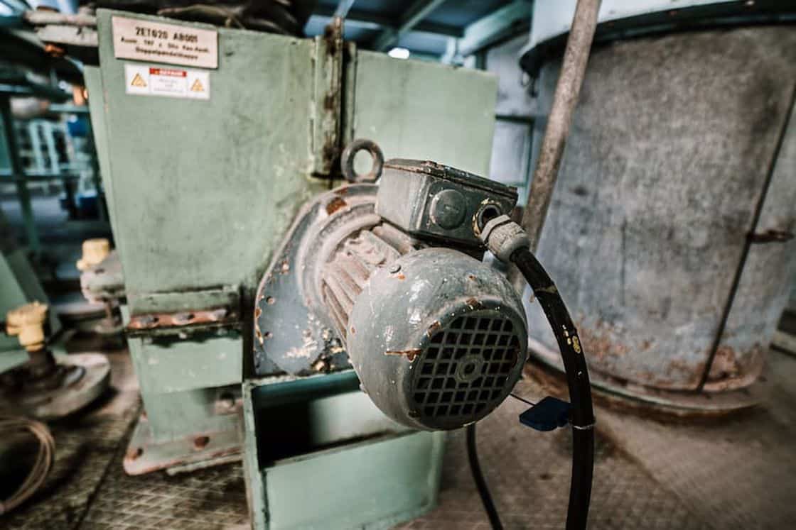 Mechanical grade air compressor showing wear and tear while being used in a factory