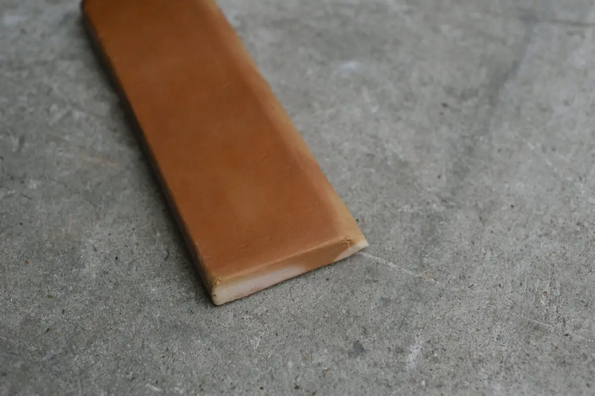 A piece of brown baseboard on the ground