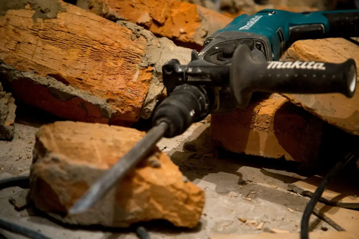 A green masonry Makita Chipper used for cutting bricks on the work-field.