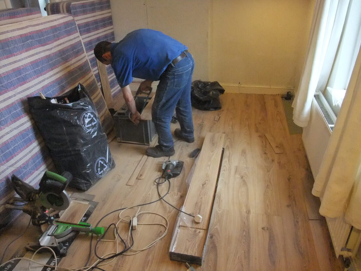 A busy man cutting a laminate to install on the flooring