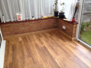 A room with brown laminated flooring