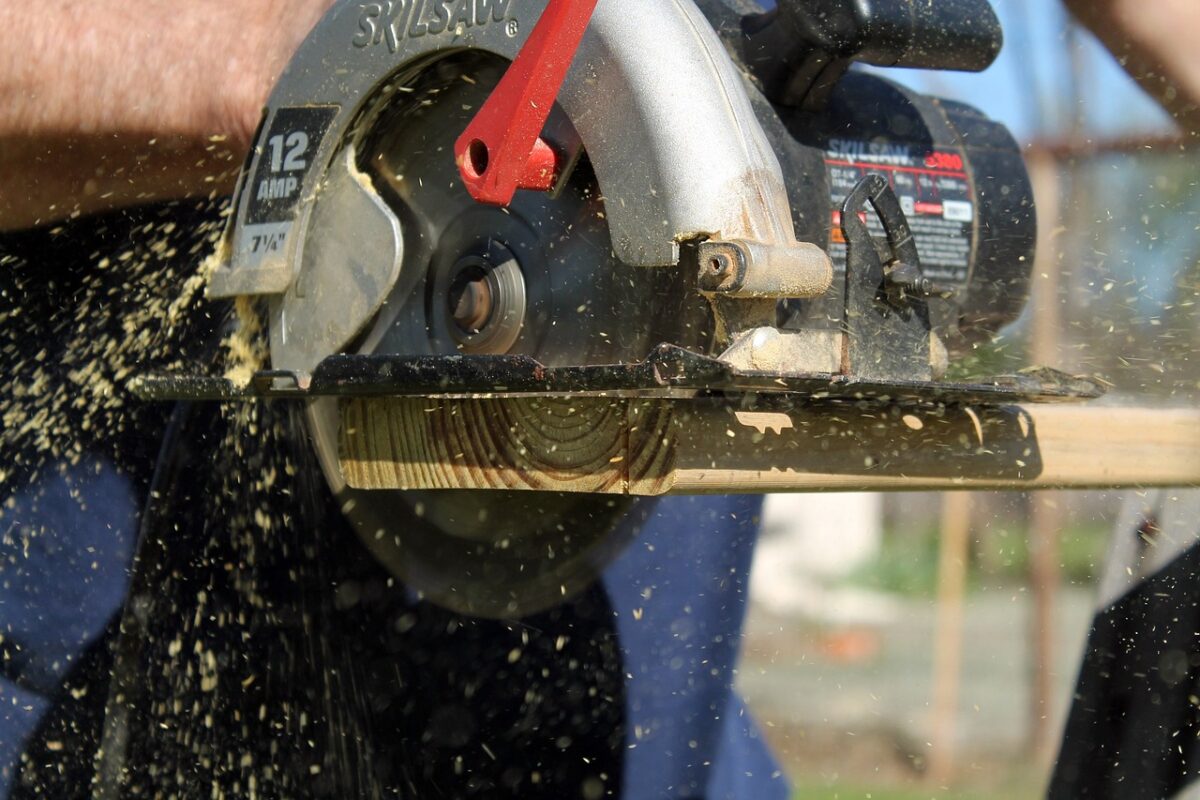 A black Skilsaw circular saw cutting a wood in a workshop