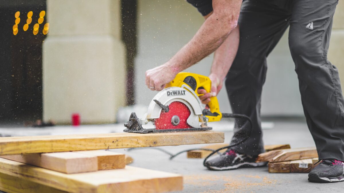 A yellow handled circular saw swiftly cutting a laminate in a workshop