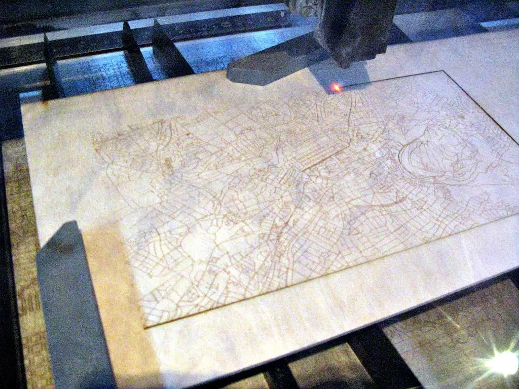 A plywood being cut using a laser