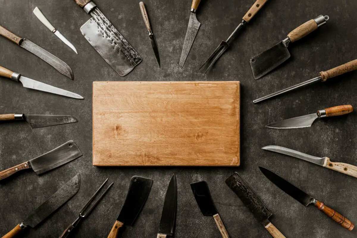 Different kinds of sharp knife with a wooden board in the middle