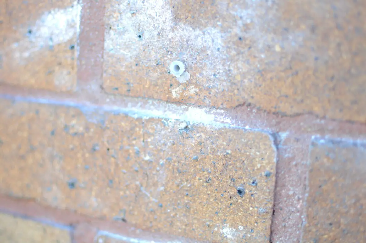 A wall with a small drilled hole